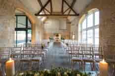 Interior of our Cotswold wedding venue, looking west down the aisle in Stone Barn