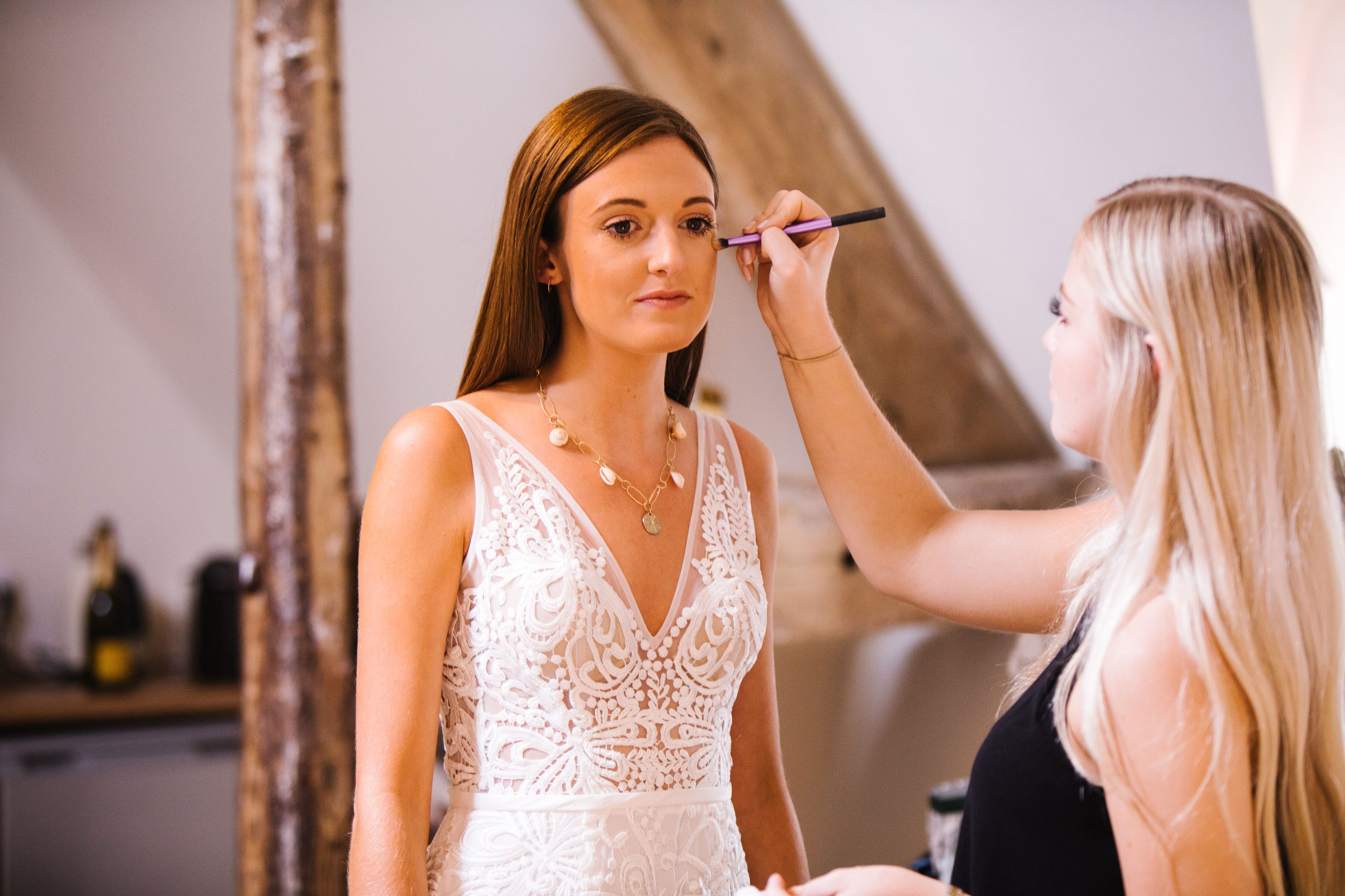 Bride having her make-up finished before the wedding ceremony