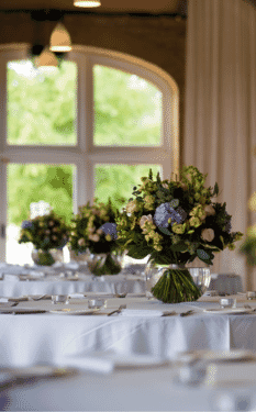Tables laid for the wedding breakfast with floral arrangements by The Broadway Florist