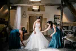 Bride and bridesmaids making final preparations in the Hayloft